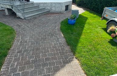 Gereinigte Pflasterfläche in Mainz: Vorher-Nachher Steinreinigung einer Einfahrt. Das Ergebnis zeigt saubere Steine ohne Moos.