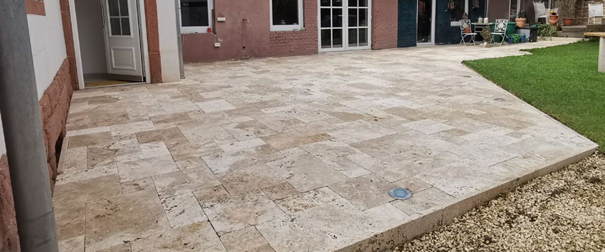 Terrasse mit Travertin Pflastersteinen. Reinigungsergebnis auf der gepflasterten Fläche. Vorher Nachher Effekt. Homepage