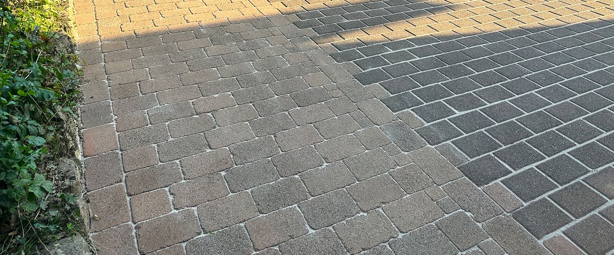 Vorher Nachher: Gereinigte Pflasterfläche. Die eine Hälfte ist sauber, die andere vermoost. Reinigung durch Fachbetrieb von der Homepage.