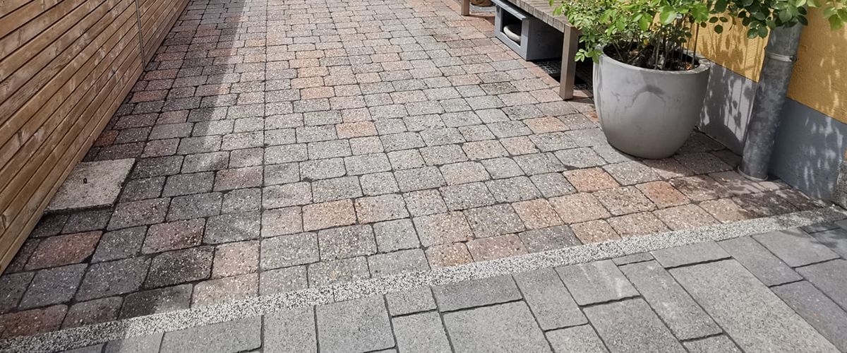 Gereinigte Pflasterfläche im Außenbereich. Vorher/Nachher-Effekt der Steinreinigung. Jetzt strahlend sauber und einladend.