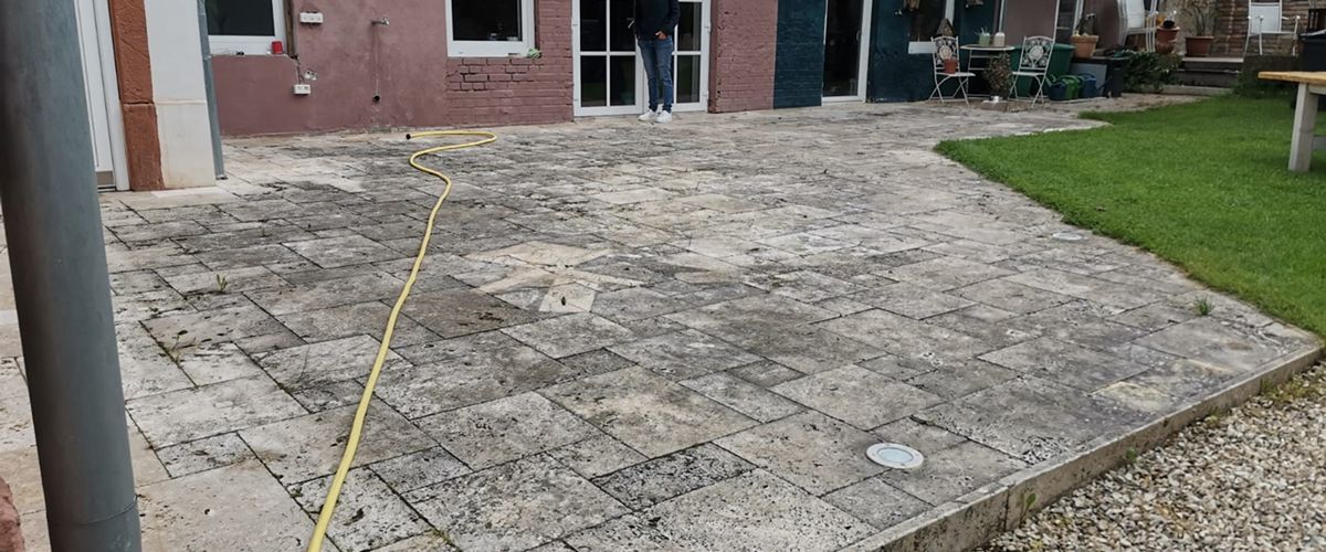 Vermooste Pflasterfläche vor der Reinigung. Die Terrasse ist stark verschmutzt. Reinigungsservice für Ihre Homepage.